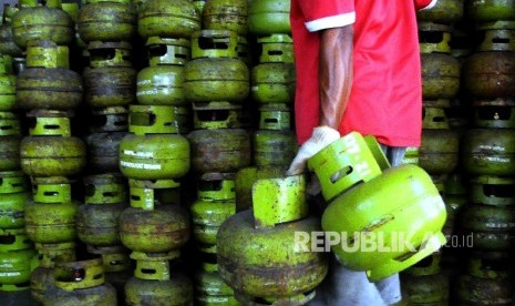 Pekerja membawa tabung elpiji tiga kilogram (gas melon) untuk dipindahkan ke truk pengangkut gas di agen penjualan gas, Mampang, Jakarta, Senin (31/10).