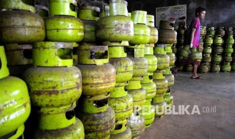 Pekerja membawa tabung gas elpiji tiga kilogram (gas melon) untuk dipindahkan ke truk pengangkut gas di agen penjualan gas, Mampang, Jakarta, Senin (31/10).