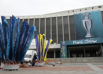 Pekerja membenahi umbul-umbul di depan Palace of Arts, Kiev, Ukraina, Kamis (1/12). Pengundian Euro 2012 akan digelar pada Jumat (2/12). 