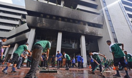 Pekerja membersihkan air sisa dari upaya pemadaman kebakaran di gedung RM Notohamiprodjo Radius Prawiro, komplek Kementerian Keuangan, Jakarta Pusat, Jumat (25/7). 