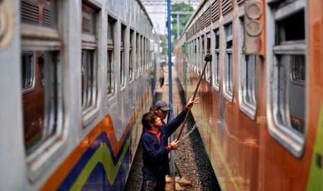 Pekerja membersihkan gerbong kereta api di Stasiun Pasar Senen, Jakarta, Minggu (12/8).