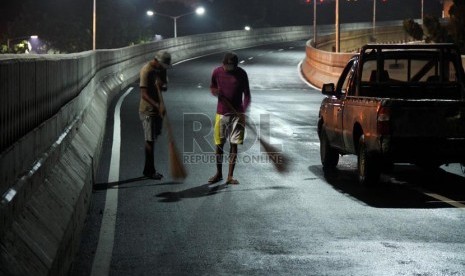  Pekerja membersihkan jalan layang non tol Antasari - Blok M, Jakarta, Ahad (13/1). (Republika/Yasin Habibi)