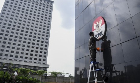 Pekerja membersihkan logo KPK, di Gedung Merah Putih, Jakarta, Senin (5/8).