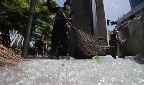 Pekerja membersihkan pecahan kaca akibat ledakan di Kuil Erawan persimpangan Rajprasong, Bangkok, Thailand, Selasa (18/8).