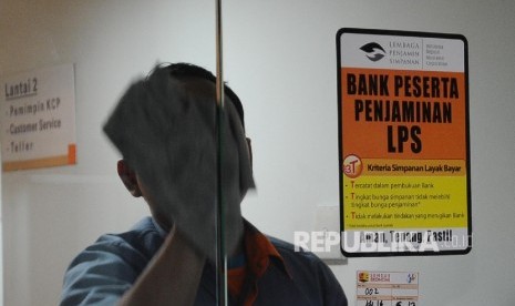 Pekerja membersihkan pintu kaca di salah satu Bank Peserta Penjaminan, Jakarta, Rabu (4\1)