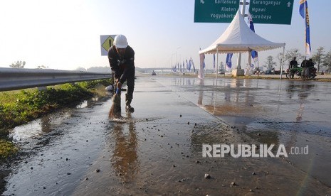 Pekerja membersihkan sisa material pembangunan ruas tol Salatiga-Boyolali di Banyudono, Boyolali, Jawa Tengah, Kamis (7/6). 