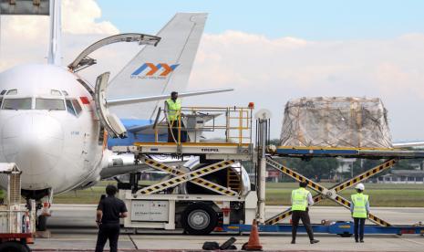 Pekerja membongkar muat paket berisi vaksin Pfizer dari sebuah pesawat kargo setibanya di Terminal Cargo Bandara Internasional Juanda, Sidoarjo, Jawa Timur, Kamis (16/9/2021). 