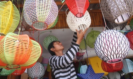 Pekerja membuat kerajinan lampu meja dari rotan sintetis sebelum diekspor ke Italia di Desa Mojorejo, Batu, Jawa Timur, Rabu (30/3).