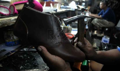 Pekerja membuat sepatu pesanan di tempat produksi rumahan di Kawasan Kuningan, Jakarta, Jumat (26/9).(Republika/Prayogi)