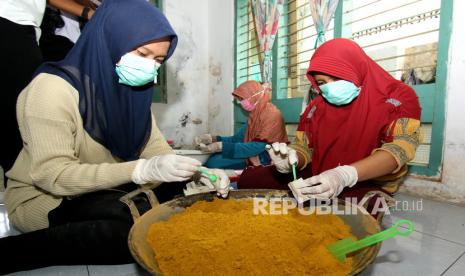 Pekerja membungkus bubuk olahan jamu temulawak di Pengantigan, Banyuwangi, Jawa Timur, Rabu (4/3/2020).