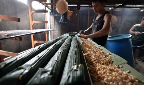 Pekerja membungkus tempe untuk difermentasi di sentra produksi Talang Banjar, Jambi Timur, Jambi, Minggu (18/1)