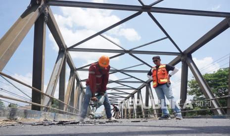 Pekerja memecah lapisan aspal pada area badan jembatan yang rusak di Jembatan Karangrejo, Tulungagung, Jawa Timur, Jumat (10/9/2021). Perbaikan itu dilakukan karena alas lantai jembatan konstruksi rangka baja yang dibangun sejak 1990 itu mengalami kerusakan sehingga membahayakan kendaraan yang melintas di atasnya. 