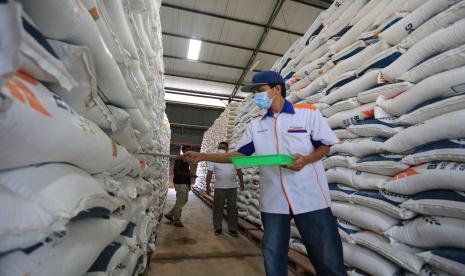 Pekerja memeriksa stok beras di gudang Bulog Sub divre Indramayu, Jawa Barat