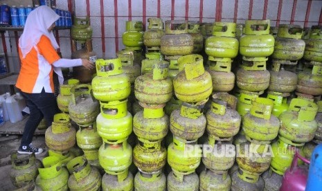  Pekerja memeriksa tabung gas tiga kilo di tempat penjualan gas di Jakarta, Ahad (2/4).