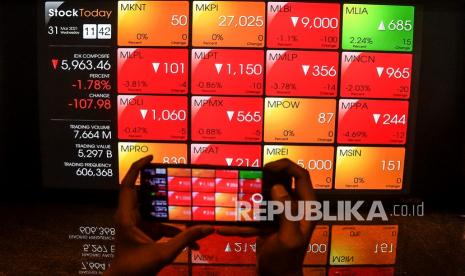 Pekerja memfoto layar pergerakan harga saham di Bursa Efek Indonesia, Jakarta, Rabu (31/3). Posisi IHSG per 8 April 2021 lalu sudah kembali ke posisi 6.071,72 atau naik 1,55 persen dari Desember 2020.