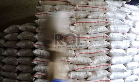 Pekerja memikul karung beras di Pasar Induk Cipinang, Jakarta, Kamis (15/10). 