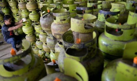 Pekerja memindahkan sejumlah tabung LPG 3 kilogram untuk didistribusikan ke pengecer di salah satu agen di Jakarta, Senin (23/2).