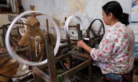 Pekerja memintal benang bahan sarung di industri sarung tenun Gloyor cap Botol Terbang kelurahan Potrobangsan, Kota Magelang, Jawa Tengah Kamis (23/5/2019).