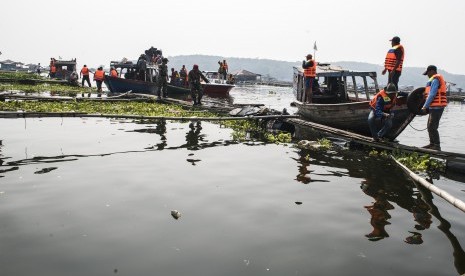 Pekerja memotong besi keramba jaring apung saat penertiban di waduk Cirata, Kabupaten Bandung Barat, Jawa Barat, Kamis (19/7).