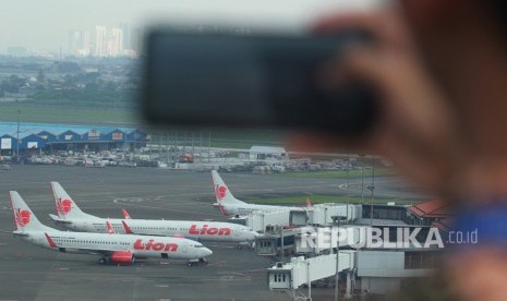 Pekerja memotret sejumlah pesawat yang terparkir di Bandara Soekarno Hatta.