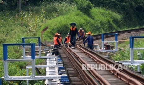 Pekerja memperbaiki bantaran rel kereta api jalur selatan Pulau Jawa. ilustrasi