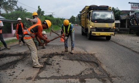 Pekerja memperbaiki Jalan Lintas Sumatra (Jalinsum) di Pemayung, Batanghari, Jambi, Senin (20/5/2019).