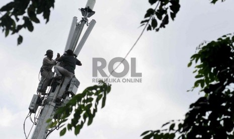  Pekerja memperbaiki menara pemancar telekomunikasi di Jakarta, Selasa (12/8). 