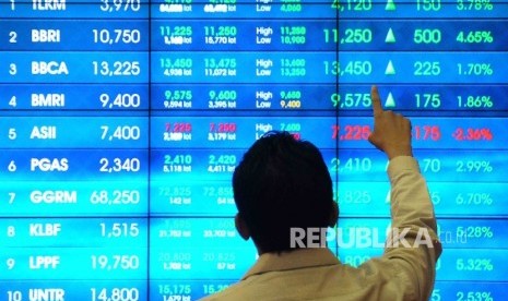 Pekerja memperhatikan layar pergerakan indeks saham di Gedung Bursa Efek Indonesia (BEI), Jakarta, Senin (11/7).