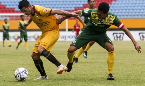 Pesepak bola Sriwijaya FC Esteban Gabriel Vizcarra (kiri) berebut bola dengan pesepak bola Persimura Zakaria (kanan) dalam pertandingan babak 64 besar Piala Indonesia di Stadion Gelora Sriwijaya Jakabaring (GSJ), Palembang, Sumatera Selatan, Jumat (14/12/2018). 