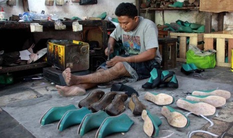 Pekerja memproduksi sepatu dan sandal kulit di bengkel rumahan Sentra Kerajinan Kulit Tanggulangin, Sidoarjo, Jawa Timur. (Republika/ Yasin Habibi).