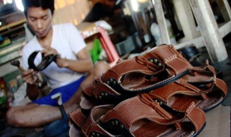 Pekerja memproduksi sepatu dan sandal kulit di bengkel rumahan Sentra Kerajinan Kulit Tanggulangin, Sidoarjo.