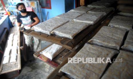 Pekerja memproduksi tempe berbahan kedelai impor di sentra industri rumahan.