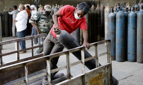 Pekerja memuat tabung oksigen di stasiun pengisian di pinggiran Prayagraj, India, Jumat, 23 April 2021. Otoritas India bergegas Sabtu untuk membawa tangki oksigen ke rumah sakit tempat pasien COVID-19 mati lemas di tengah gelombang virus korona terburuk di dunia, saat pemerintah mendapat kecaman yang meningkat atas apa yang dikatakan dokter sebagai kelalaian dalam menghadapi bencana kesehatan masyarakat yang dapat diperkirakan.