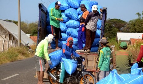 Pekerja menaikkan garam rakyat ke atas truk di Desa Bunder, Pamekasan, Jawa Timur, Kamis (20/6/2019).