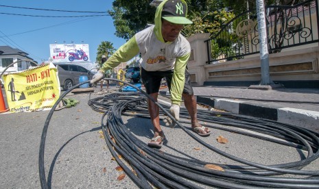 Pekerja menarik kabel serat optik milik PT. Telkom pada proyek pemeliharaan jaringan di Palu, Sulawesi Tengah, Rabu (20/3/2019).