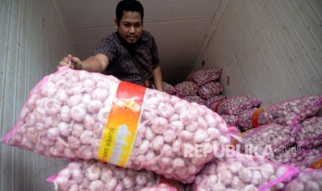  Pekerja menata bawang putih saat dilaksanakananya operasi pasar komoditas bawang putih di Pasar Senen, Jakarta, Kamis (1/6). 