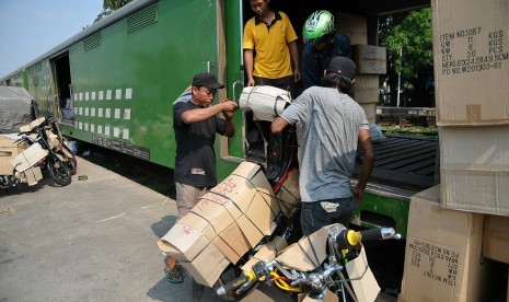 Pekerja menata sepeda motor yang akan dikirim melalui jasa pengiriman kereta api.