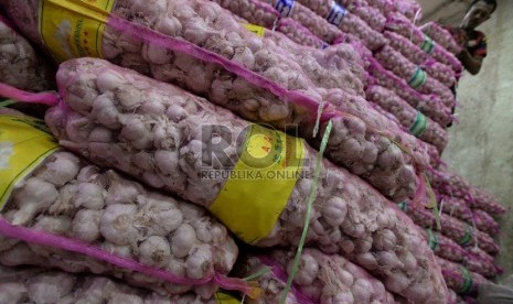 Pekerja menata tumpukan bawang putih impor di Pasar Induk Kramat Jati ,Jakarta, Kamis (5/3).