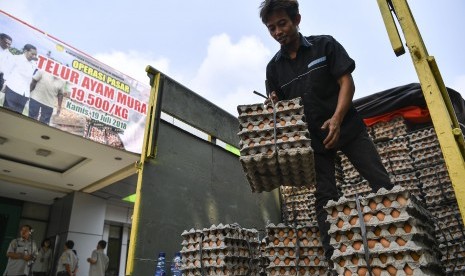 Pekerja mengangkat telur ayam yang akan didistribusikan untuk operasi pasar di Toko Tani Indonesia Centre, Jakarta Selatan, Kamis (19/7).