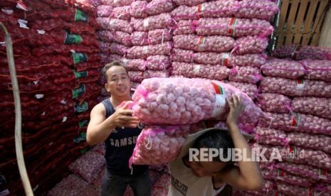 Pekerja mengangkut bawang putih di Pasar Induk Kramat Jati, Jakarta, Rabu (17/5).