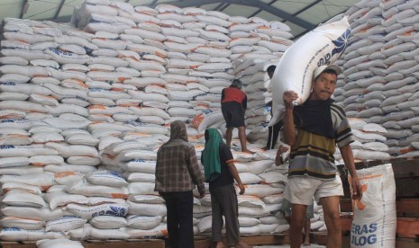 Pekerja mengangkut beras di gudang beras Bulog, Jl Gedebage, Kota Bandung, Selasa (29/3).