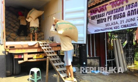 Pekerja mengangkut karung biji kopi (green been) asal Gunung Puntang ke dalam truk kontainer untuk diekspor ke Maroko, Afrika Utara, di Desa Pasirhuni, Kecamatan Cimaung, Kabupaten Bandung, Rabu (22/6). (Republika/Umar Mukhtar)