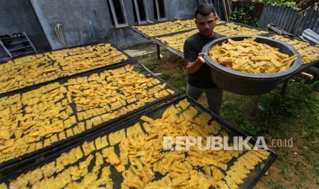 Pekerja mengangkut kerupuk tempe yang sudah kering di Desa Blang Cut, Kecamatan Blang Mangat, Lhokseumawe, Aceh, Rabu (9/3/2022). Perajin kerupuk tempe terpaksa menurunkan produksinya hingga 50 persen dan menaikkan harga jual dari Rp17 ribu per kilogram menjadi Rp18 ribu per kilogram lantaran tingginya harga bahan baku dan upaya bertahan di tengah pandemi COVID-19. 