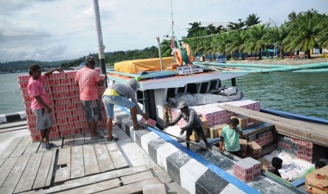 Pekerja mengangkut logistik yang akan dikirim ke wilayah Wasior menggunakan kapal di dermaga TNI AL, Manokwari, Papua Barat, Rabu (3/12).