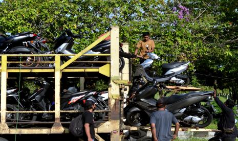 Pekerja mengangkut sepeda motor pemudik ke atas truk (ilustrasi). Program pengangkutan sepeda motor milik pemudik oleh Kementerian Perhubungan berpotensi mengurangi kecelakaan dan masalah mobilitas pemudik di kampung halaman.