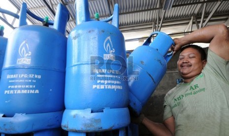 Pekerja mengangkut tabung 12 kilogram berisi liquefied petroleum gas (LPG atau elpiji).