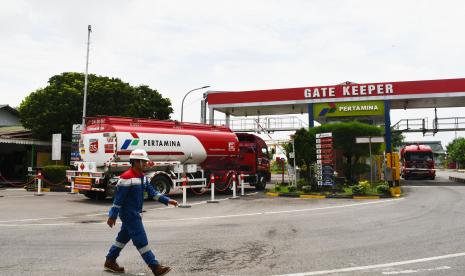 Pekerja mengatur antrean mobil tangki Pertamina untuk melakukan pengisian di depo PT Pertamina Patra Niaga Madiun, Jawa Timur, Rabu (20/4/2022) (ilustrasi).