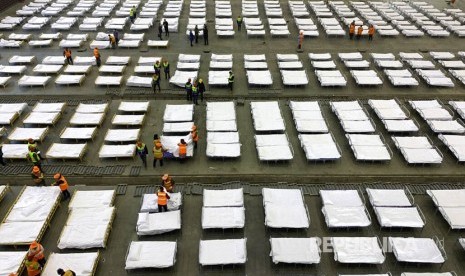 Pekerja mengatur deretan tempat tidur di sebuah gedung convention center yang disulap menjadi rumah sakit sementara di Wuhan, Hubei China, Selasa (4/1)