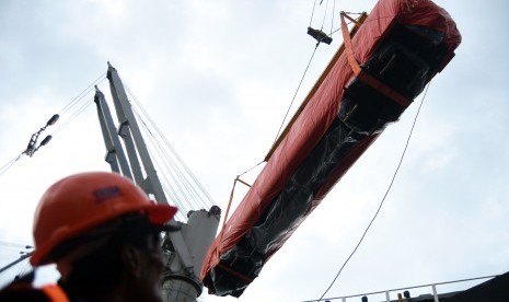 Pekerja mengawasi proses pemindahan gerbong kereta api dari truk pengangkut ke kapal kargo Seiyo Spring di Terminal Jamrud Utara Pelabuhan Tanjung Perak, Surabaya, Jawa Timur, Rabu (30/3).