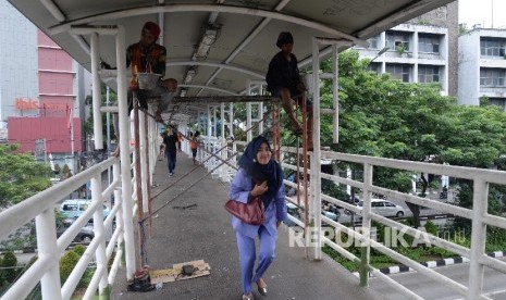 Pekerja mengecat jembatan penyeberangan orang (JPO). (Ilustrasi)